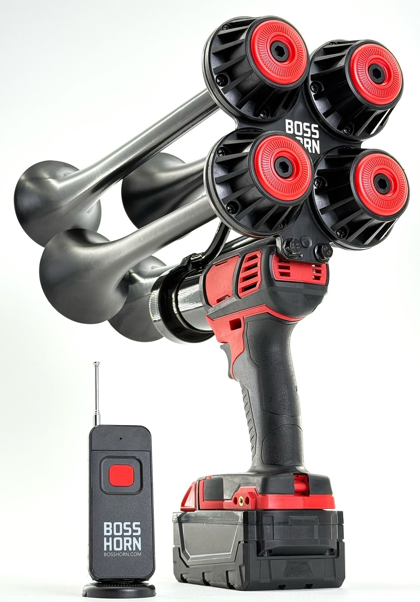 Angled studio shot of the four-trumpet train horn with red caps and curved bells, mounted on a Milwaukee® M18 battery, beside a wireless remote