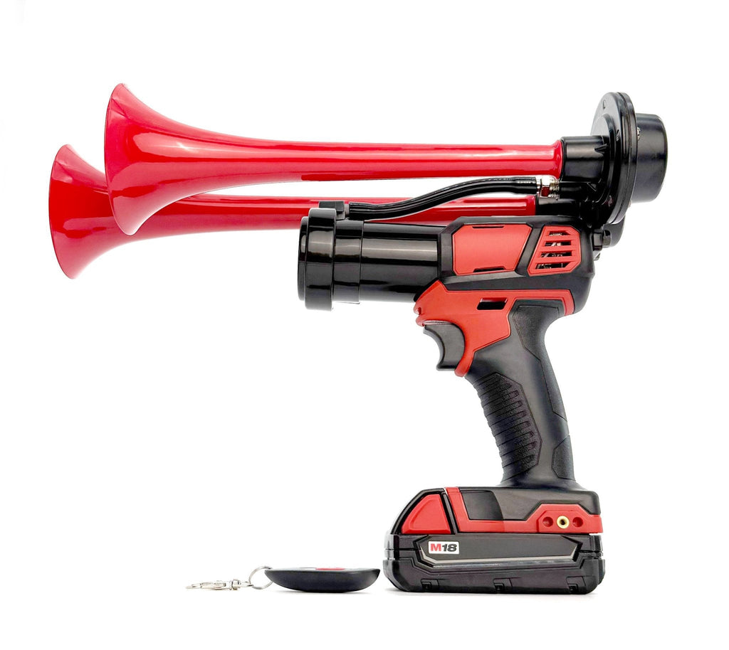 Profile of a red two-trumpet train horn powered by a cordless tool on an M18 battery, remote beside it