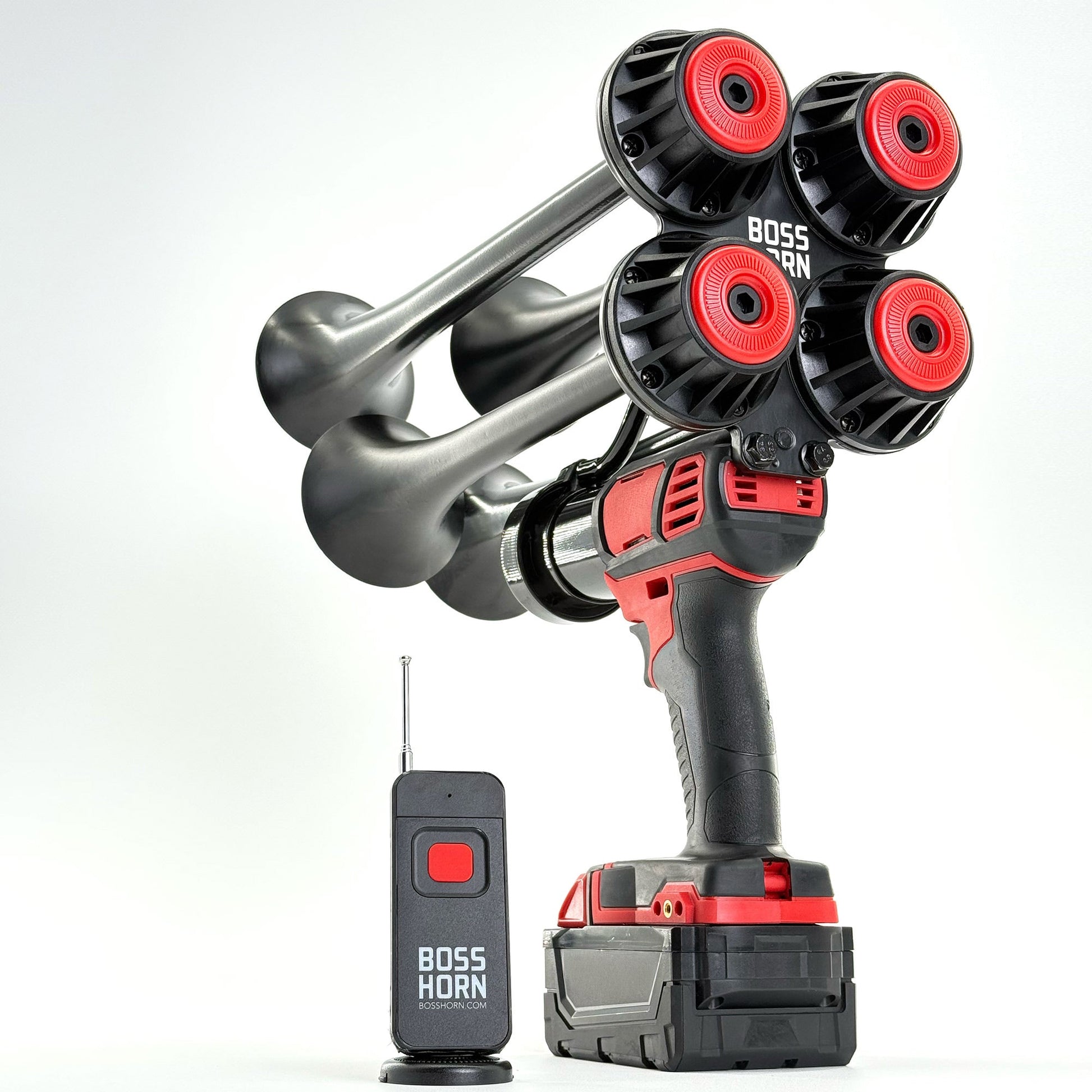 Three-quarter view of the quad-trumpet horn with red trumpet caps on a Milwaukee® M18 battery, paired with a wireless remote on white