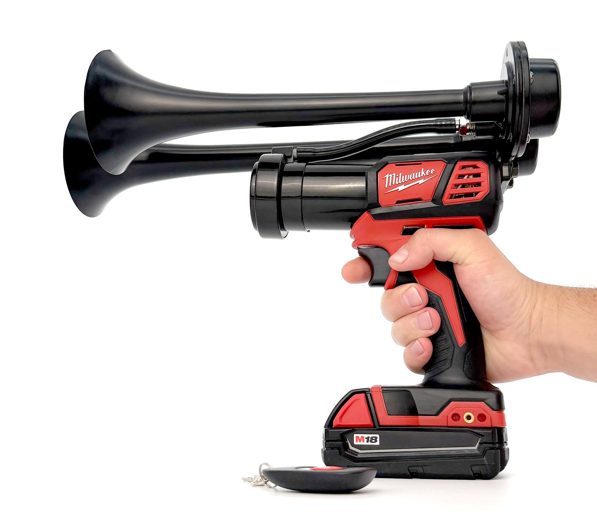 Hand holding a Milwaukee cordless air horn on a white background