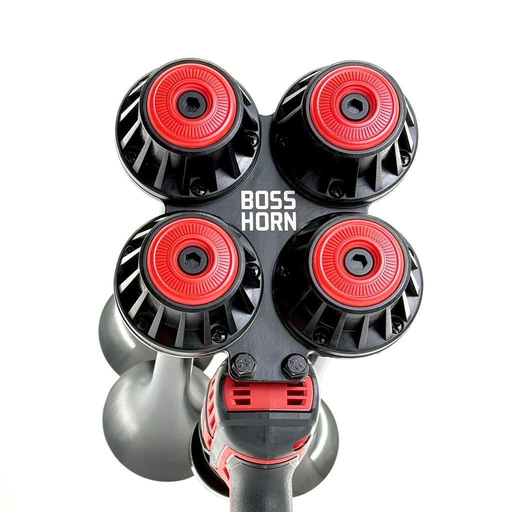 Top-down view of four black trumpets with red center caps arranged in a cluster on the horn unit against a white background